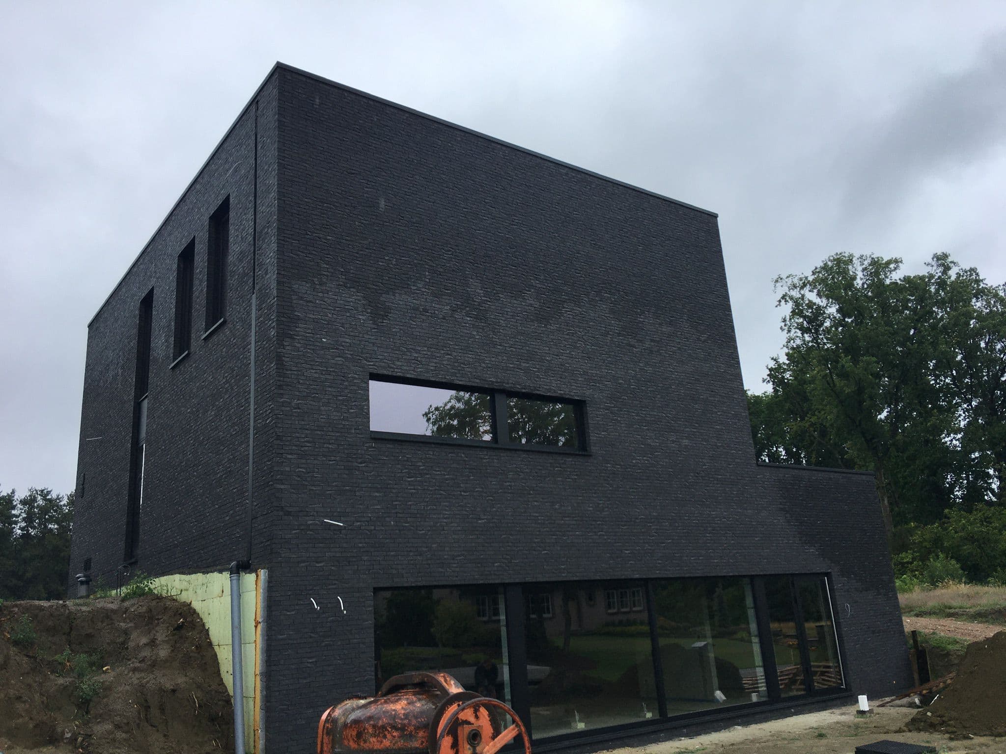 Donkere bakstenen kubieke villa met minimalistische ramen — Bouwwerken Apers