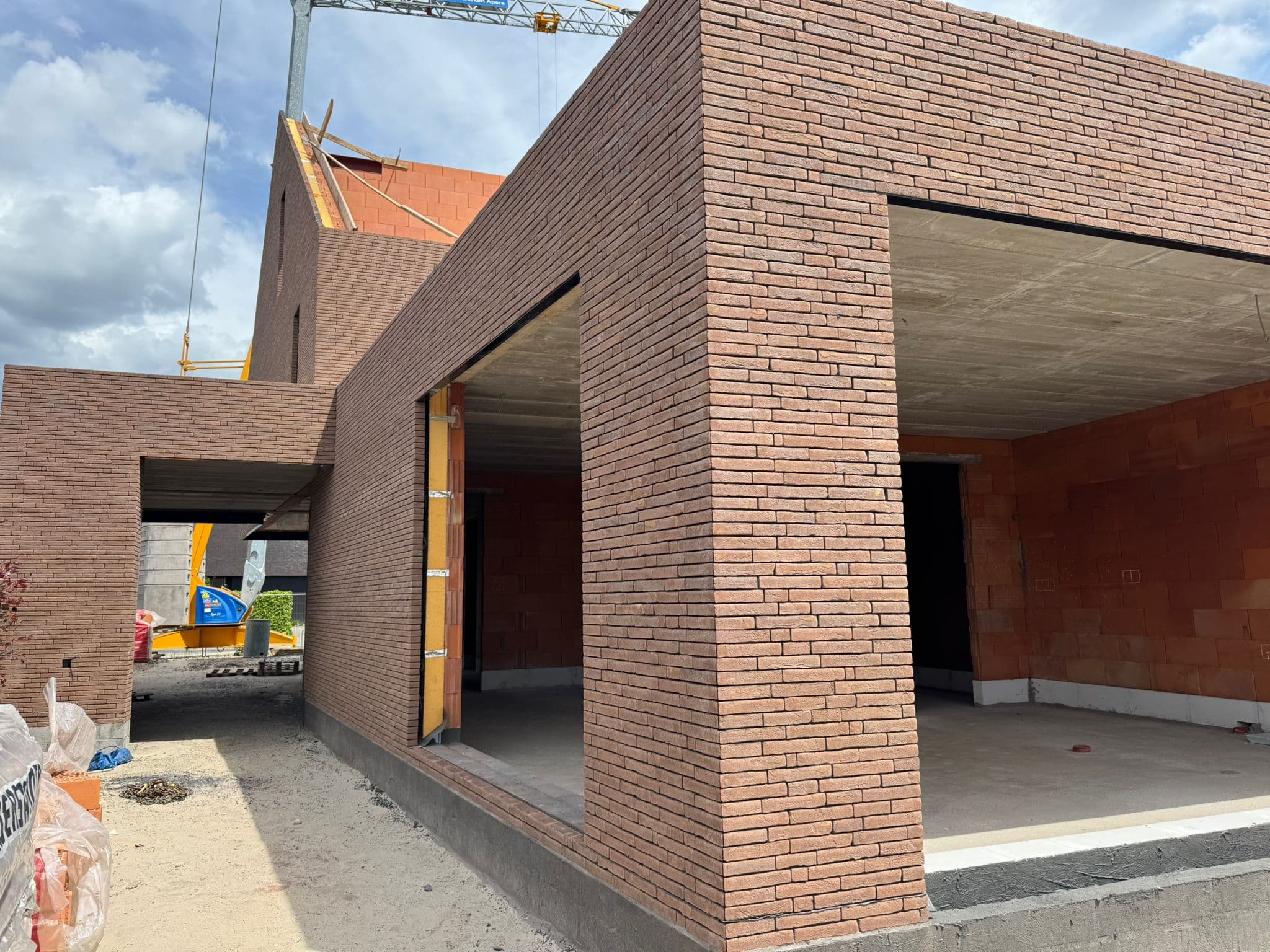 Nieuwbouw in uitvoering met gedetailleerd metselwerk en bakstenen kolommen — Bouwwerken Apers